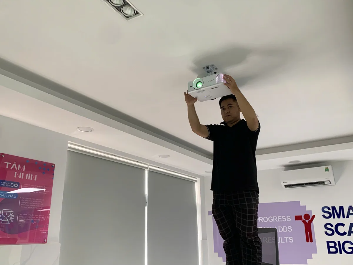 Kỹ thuật viên treo máy chiếu InFocus lên trần